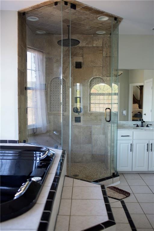 bathroom with tile patterned flooring, vanity, and walk in shower