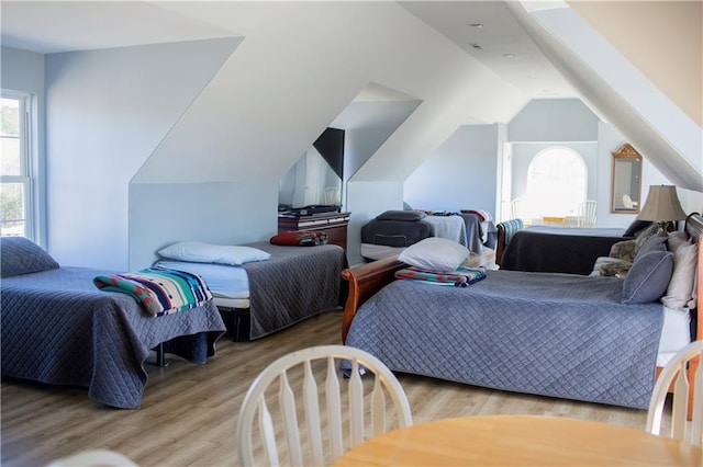 bedroom with light wood-type flooring and lofted ceiling