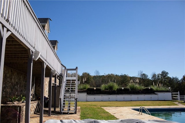 view of pool featuring a lawn and a patio