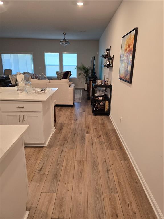1702 Villageside Ct, Lawrenceville, GA 30043 - kitchen with white cabinets, light wood-style flooring, light countertops, a chandelier, and recessed lighting