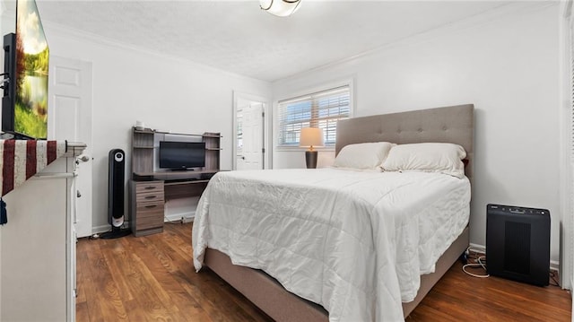 bedroom featuring wood finished floors, baseboards, and ornamental molding