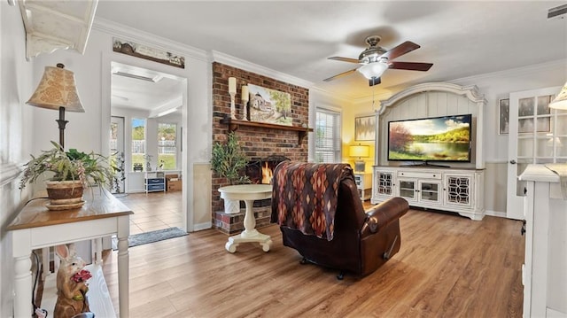 living area featuring a healthy amount of sunlight, wood finished floors, and crown molding