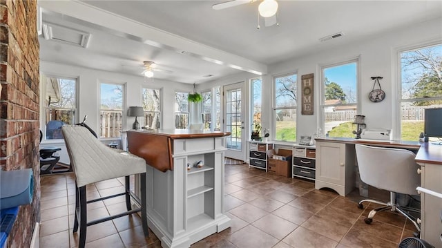 interior space with a ceiling fan, visible vents, and a wealth of natural light