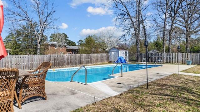 view of swimming pool with a storage shed, a fenced backyard, an outdoor structure, and a patio area