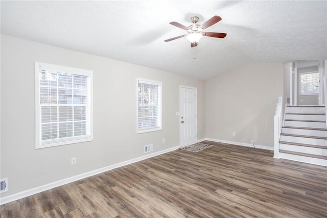 unfurnished room featuring a textured ceiling, dark hardwood / wood-style flooring, plenty of natural light, and ceiling fan