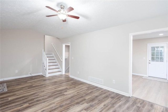 empty room featuring ceiling fan, hardwood / wood-style floors, and a textured ceiling