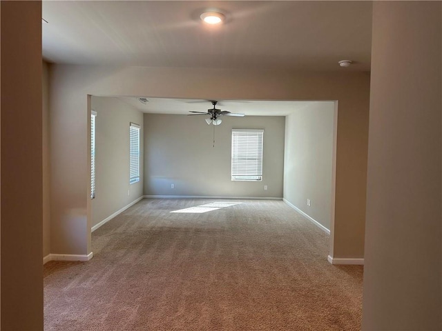 carpeted spare room with ceiling fan