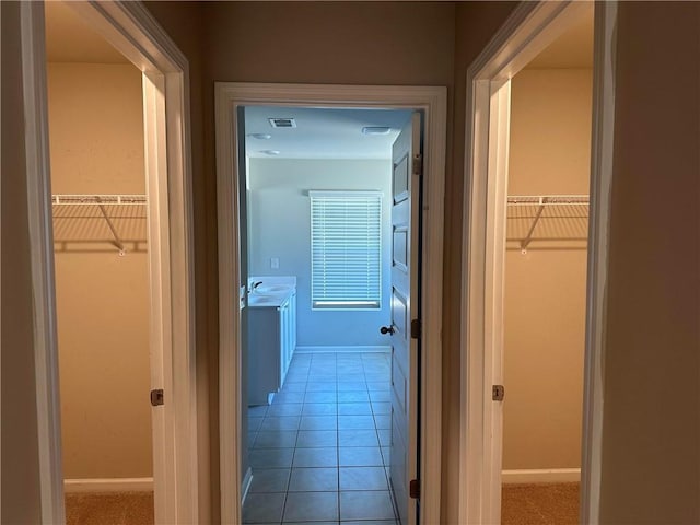 hall with light tile patterned flooring and sink