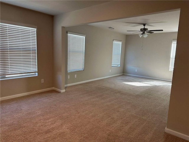 unfurnished room with light colored carpet and ceiling fan