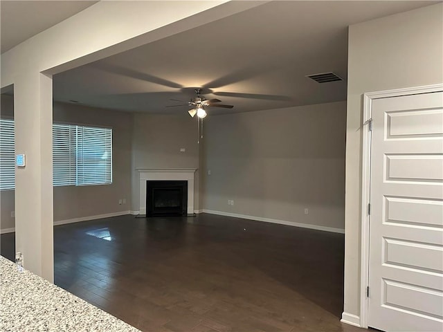 unfurnished living room with dark hardwood / wood-style flooring and ceiling fan