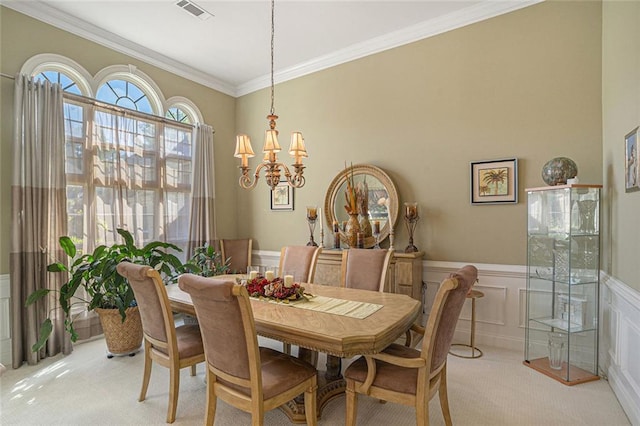 dining area with light colored carpet, visible vents, ornamental molding, and a notable chandelier