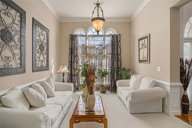 living room with a wealth of natural light, ornamental molding, and visible vents