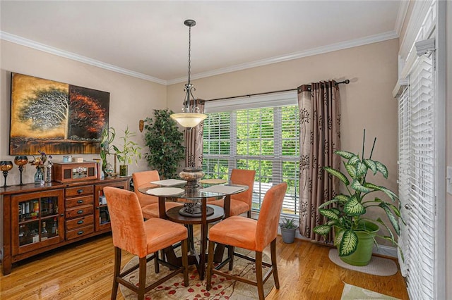 dining space featuring crown molding and light wood-style floors
