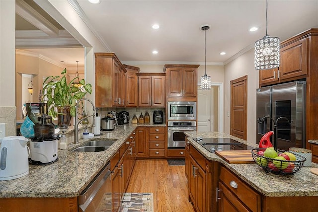 kitchen featuring a sink, brown cabinets, light wood-style flooring, and appliances with stainless steel finishes