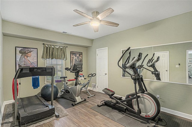 workout area featuring ceiling fan, baseboards, visible vents, and wood finished floors
