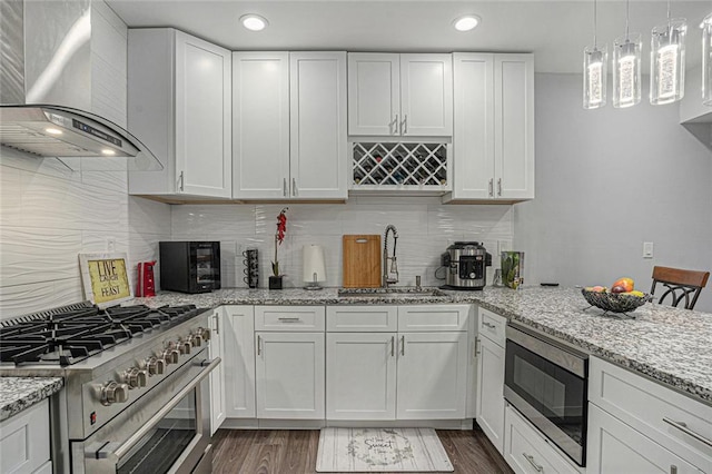 kitchen with white cabinetry, wall chimney range hood, stainless steel appliances, and a sink