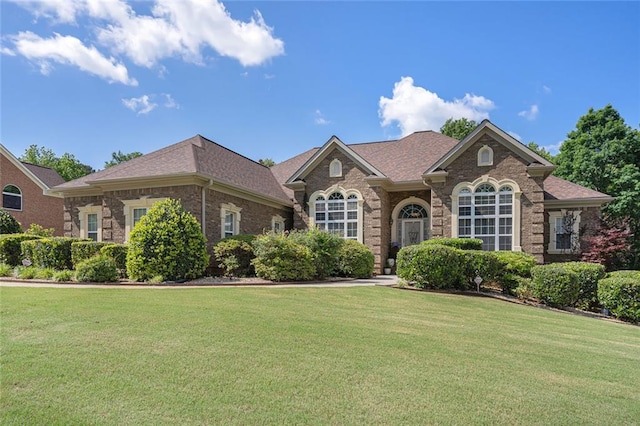 ranch-style home with brick siding and a front lawn