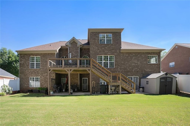 rear view of house featuring fence, a wooden deck, a shed, brick siding, and stairs