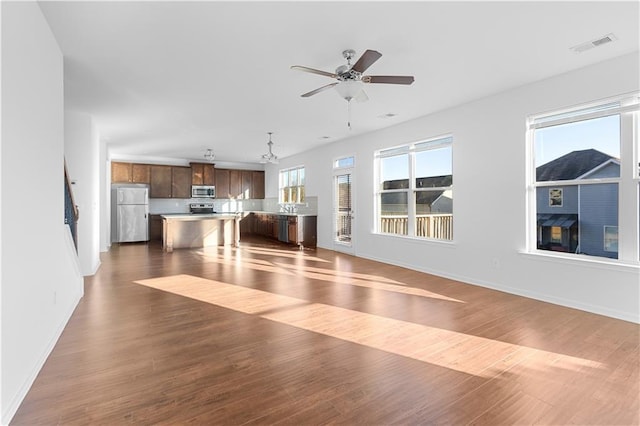 interior space featuring ceiling fan, dark hardwood / wood-style floors, and a fireplace