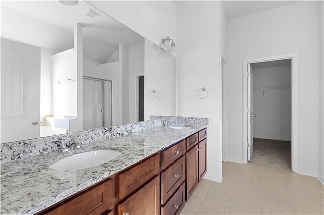 bathroom with tile patterned floors, vaulted ceiling, vanity, and a shower with shower door