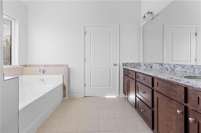 bathroom featuring vanity, tile patterned floors, and a tub to relax in