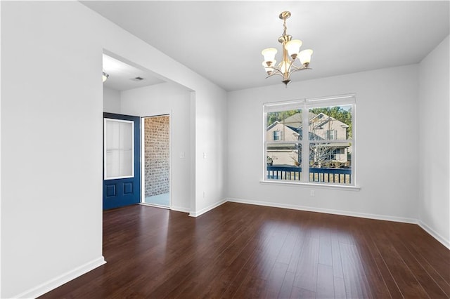 empty room featuring dark hardwood / wood-style floors and a chandelier