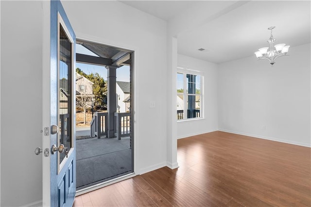 entryway featuring wood-type flooring and a notable chandelier