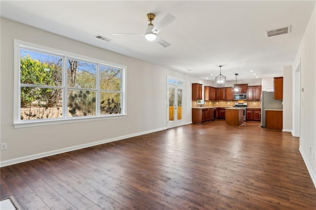 unfurnished living room featuring ceiling fan and dark hardwood / wood-style flooring