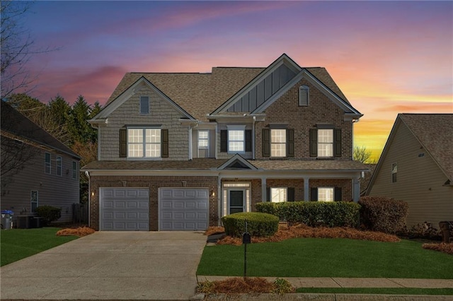 view of front of property with a garage, a yard, and cooling unit