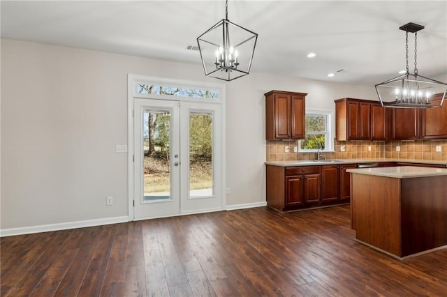 kitchen with pendant lighting, sink, tasteful backsplash, and a chandelier