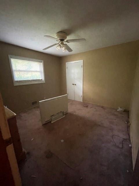 empty room featuring ceiling fan and carpet flooring