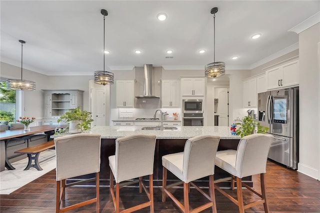 kitchen featuring wall chimney exhaust hood, stainless steel appliances, crown molding, a sink, and recessed lighting