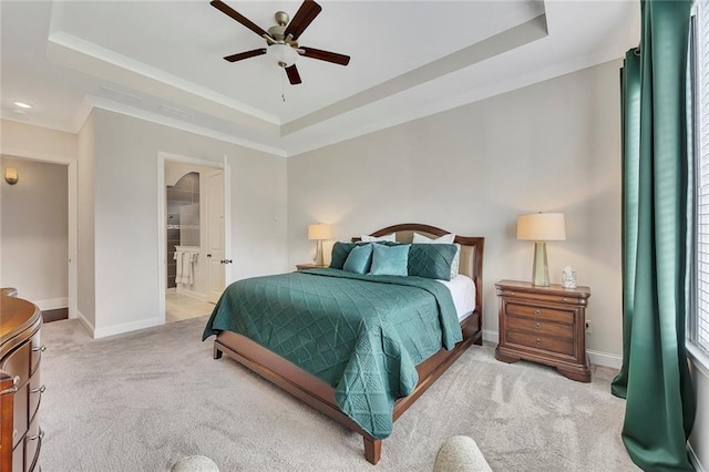 carpeted bedroom featuring a raised ceiling, baseboards, crown molding, and a ceiling fan
