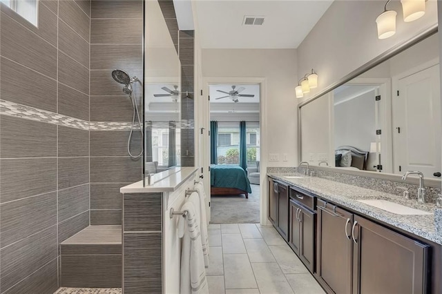 ensuite bathroom featuring double vanity, walk in shower, a ceiling fan, and tile patterned flooring