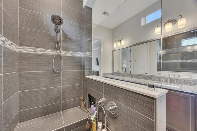 bathroom with walk in shower, vanity, and plenty of natural light