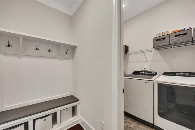 washroom featuring washer and clothes dryer, baseboards, and dark marble finish flooring