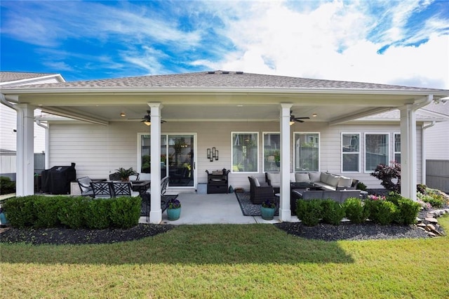 back of house with outdoor lounge area, a ceiling fan, and a yard
