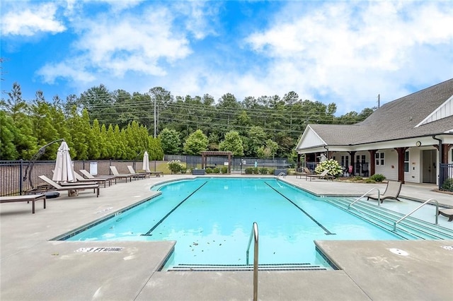community pool featuring fence and a patio