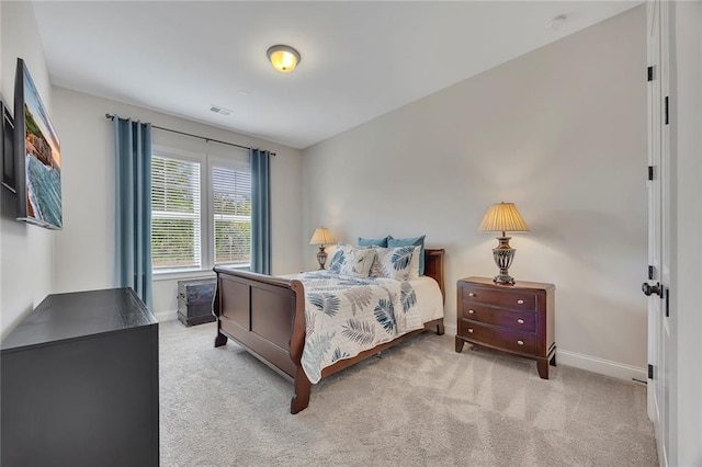 bedroom with light colored carpet and baseboards