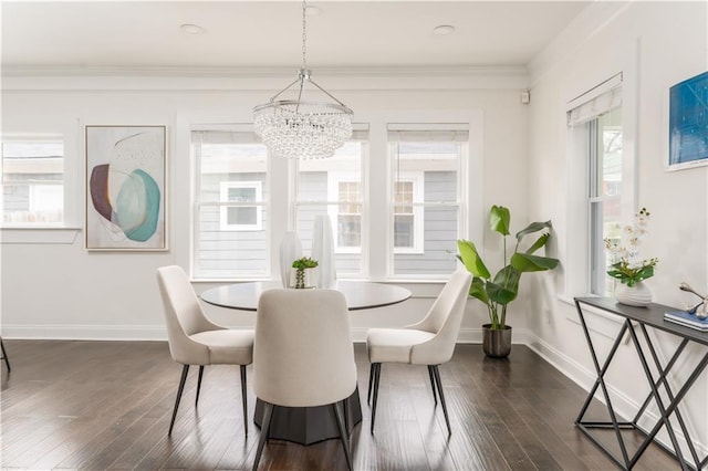 dining space featuring baseboards, dark wood-type flooring, an inviting chandelier, and crown molding