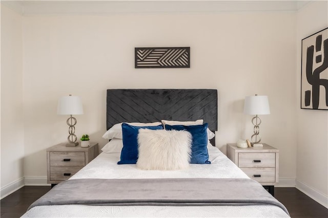 bedroom featuring baseboards, dark wood finished floors, and ornamental molding