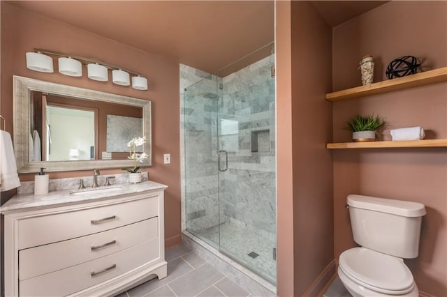 bathroom with vanity, toilet, baseboards, and a stall shower