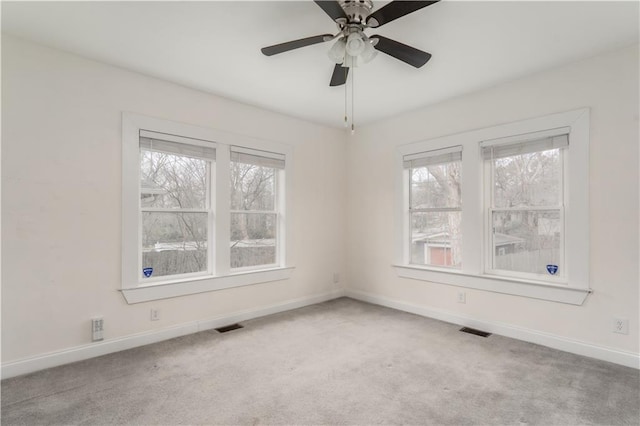 carpeted empty room featuring a ceiling fan, baseboards, and visible vents