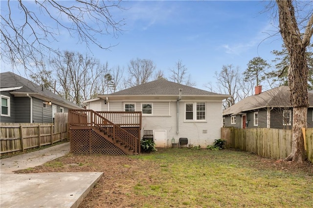 rear view of property featuring a wooden deck, a yard, a fenced backyard, and stairs