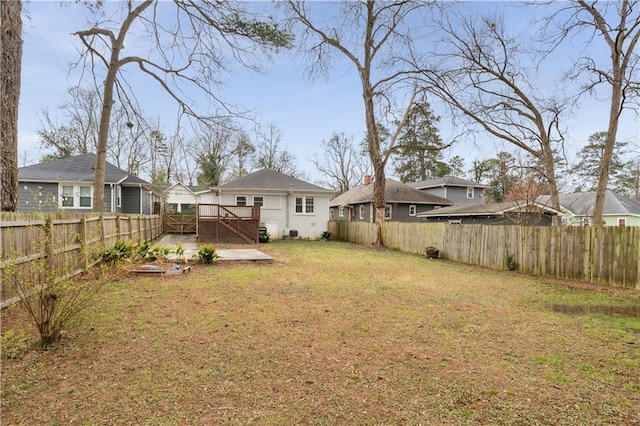 view of yard with a patio area, a wooden deck, and a fenced backyard