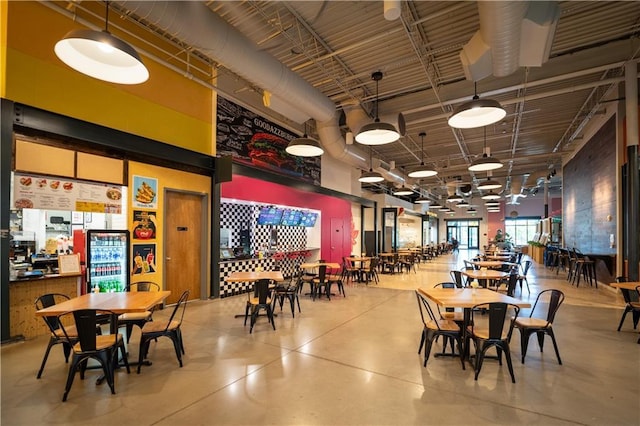 dining area featuring finished concrete floors and a towering ceiling