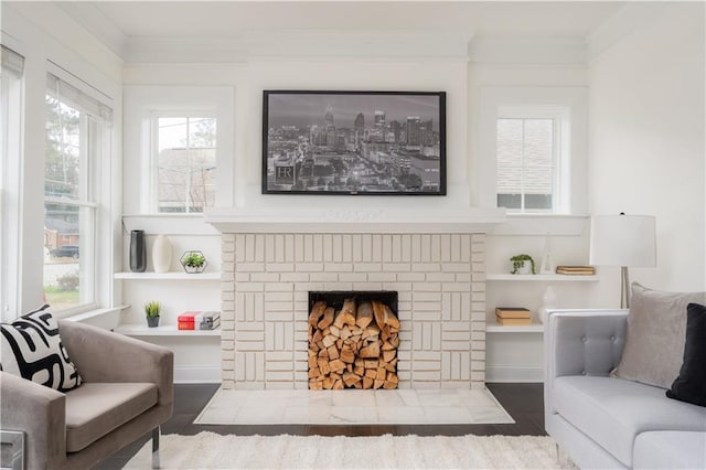 living area with crown molding and a brick fireplace