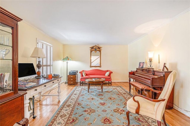 living room with baseboards, ornamental molding, and wood finished floors