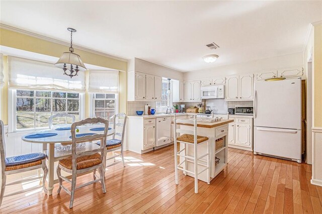 kitchen featuring light countertops, white appliances, white cabinetry, and tasteful backsplash