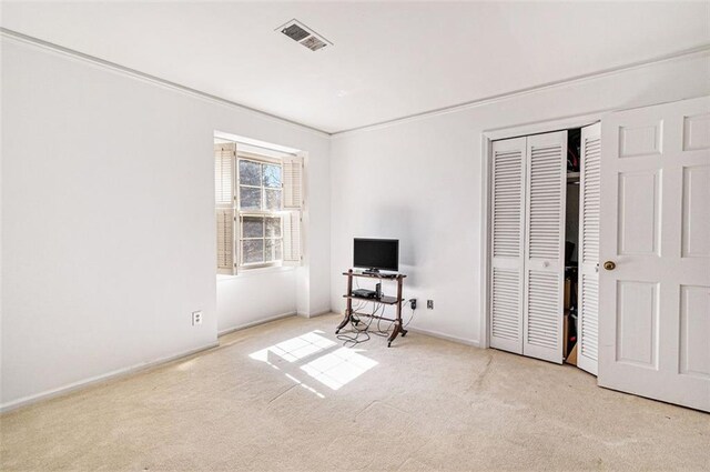 carpeted bedroom featuring a closet, visible vents, and baseboards